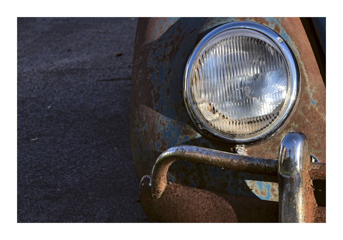 Headlight detail of a rusty vintage car